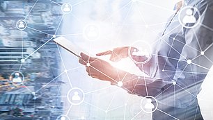 Digitale Vernetzung mit Tablet Person hält Tablet mit digitalem Netzwerk-Interface vor verschwommener Stadtkulisse