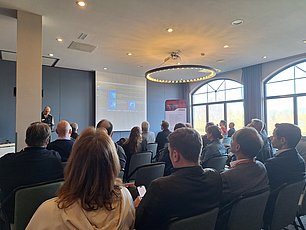 Fachveranstaltung mit Publikum im Konferenzraum Publikum verfolgt Vortrag bei einer ITEBO-Fachveranstaltung in modernem Konferenzraum