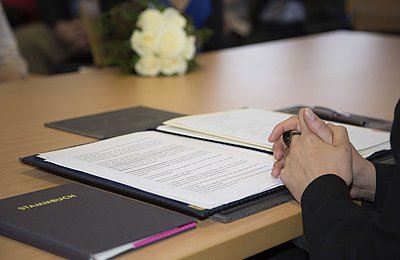 Unterzeichnung eines offiziellen Dokuments am Tisch Person unterzeichnet offizielles Dokument mit Stift an einem Konferenztisch